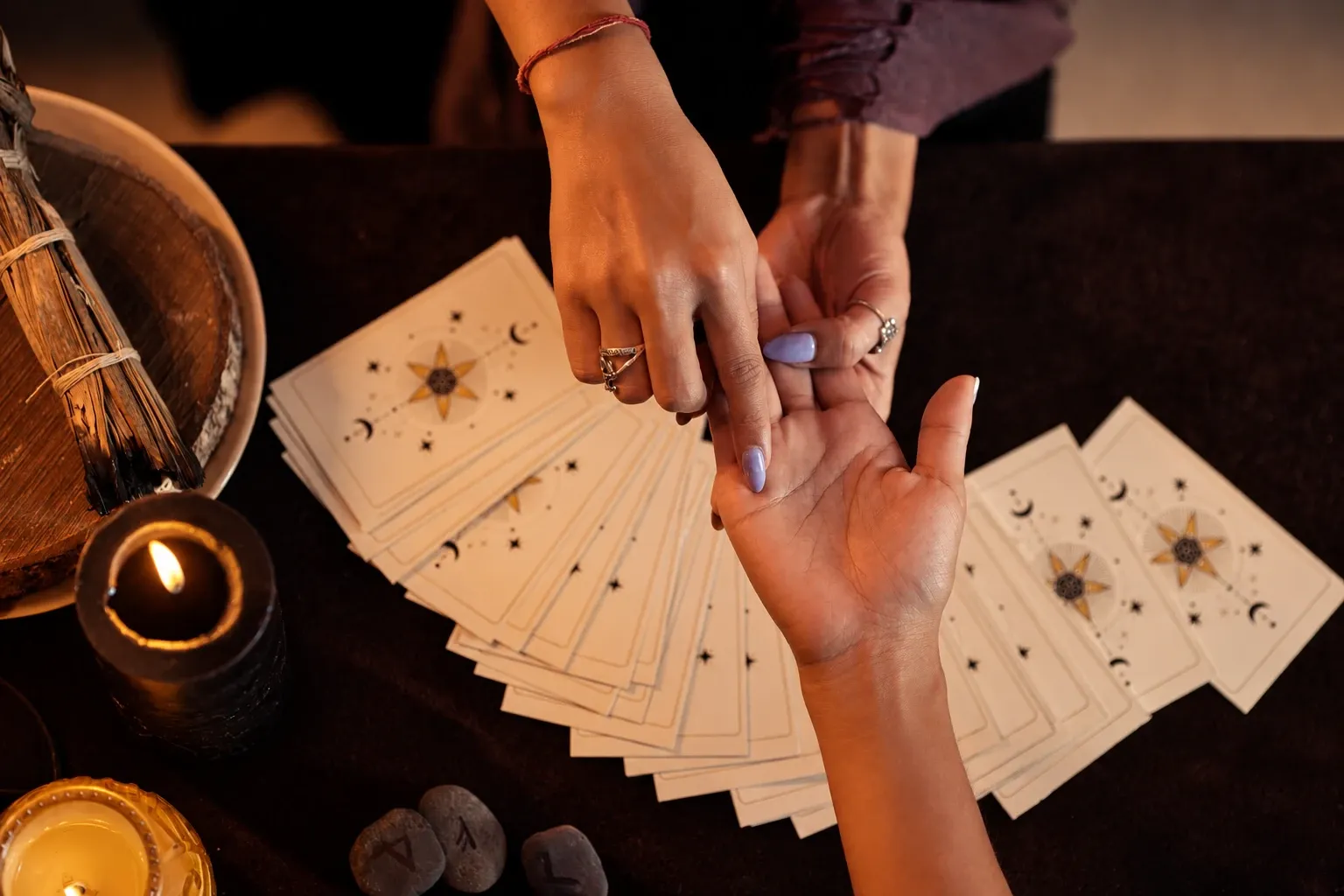 A palm reader tracing the lines of a client's open palm, with a crystal ball behind
